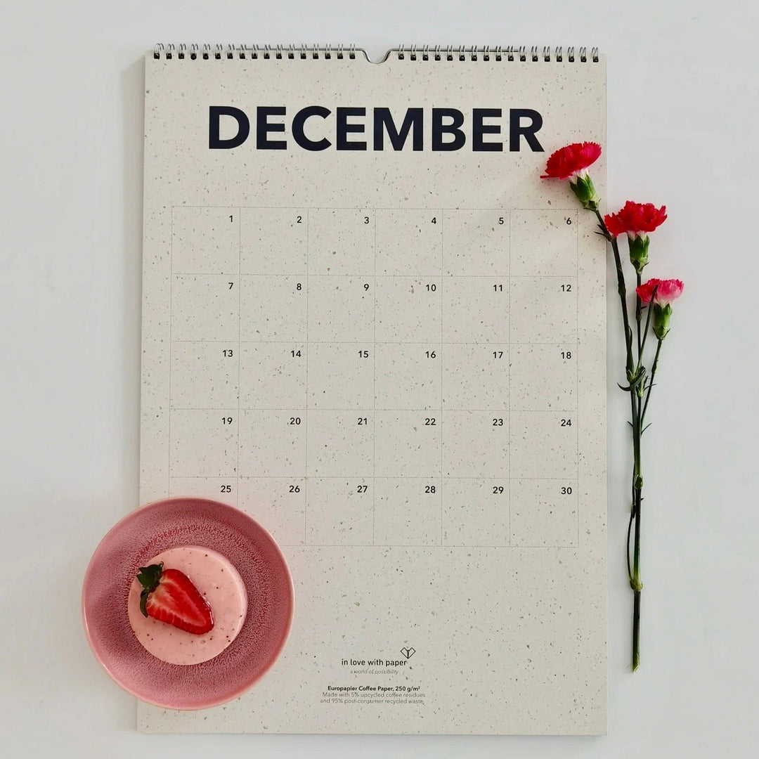 December page of the everlasting calendar with a festive touch, featuring red carnations and a pink dessert topped with a strawberry.