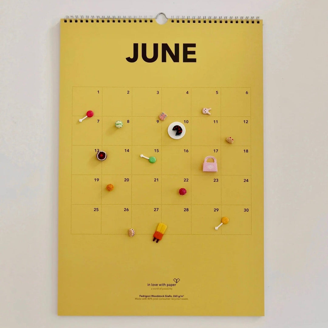 Yellow June page of the everlasting calendar decorated with colorful miniature items for a fun, summery feel.