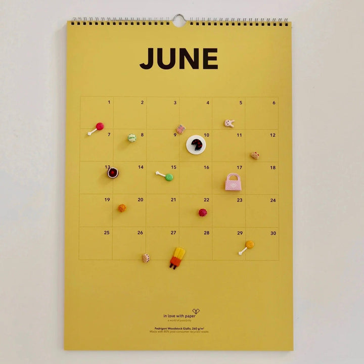 Yellow June page of the everlasting calendar decorated with colorful miniature items for a fun, summery feel.