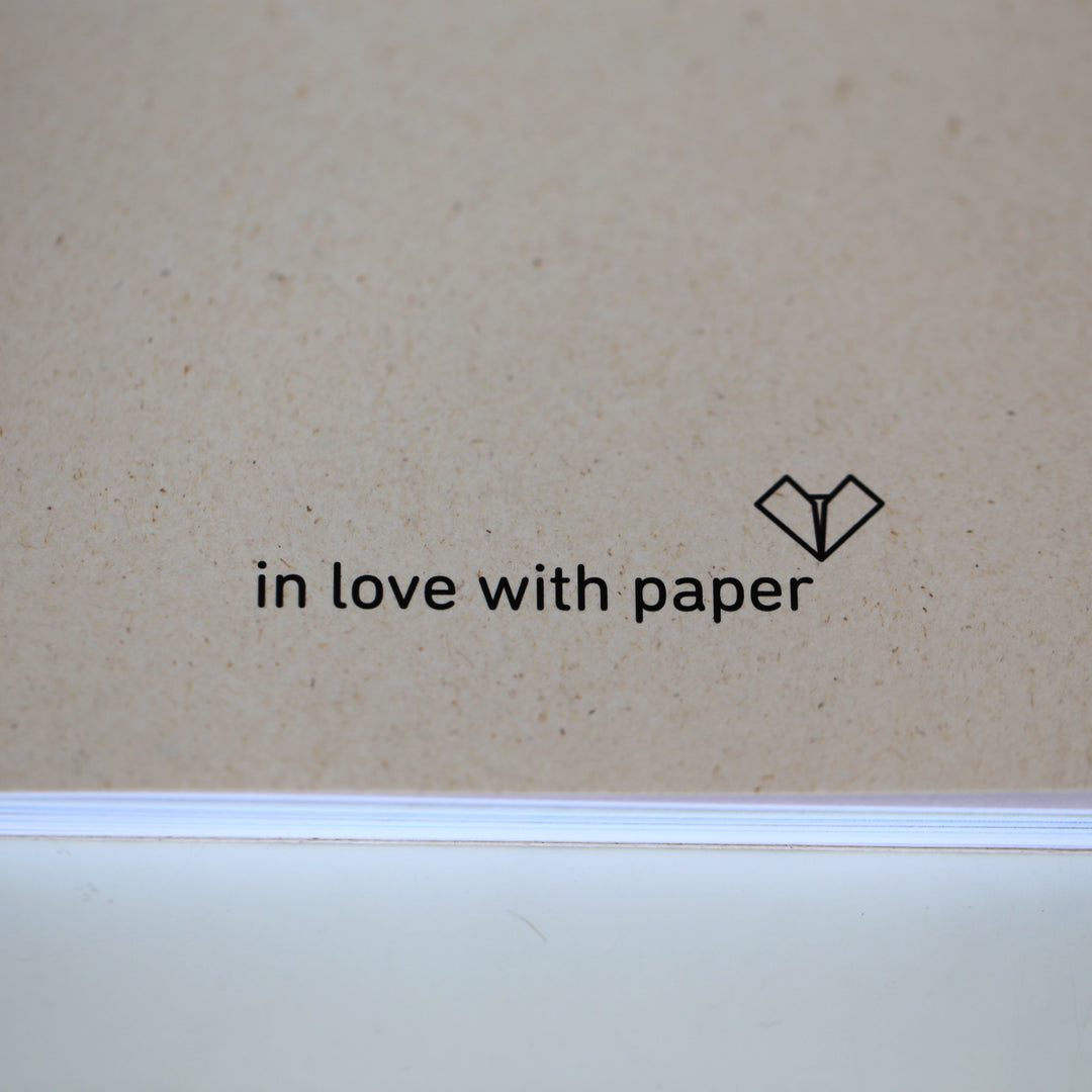 Minimalist 'in love with paper' logo on the back cover of the 'Ikigai or A Good Life' book, showcasing the eco-friendly brand identity.